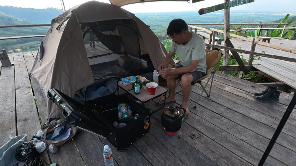 Preparing camping gear beside a Honda Cub at Khao Makhem campsite