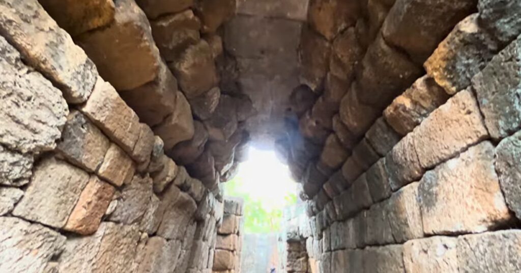 Students walking through a stone doorway at Mueang Sing Historical Park