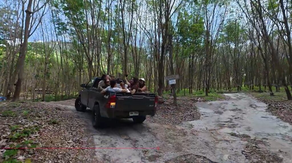 Russian travelers beside a pickup truck on the mountain road to Khao Makhem campsite