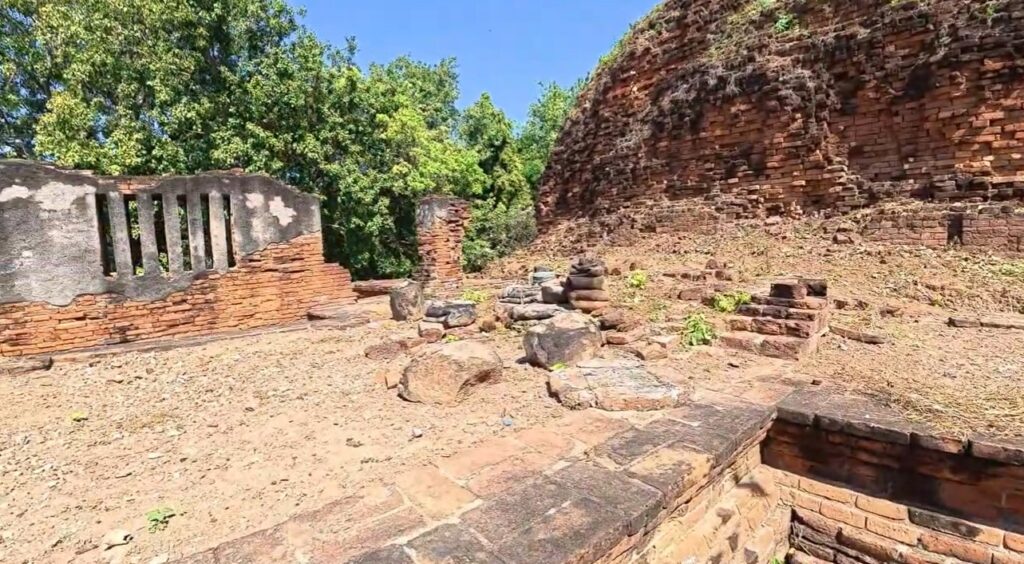 Broken brick foundations and damaged ruins at Wat Nakhon Kosa in Lopburi