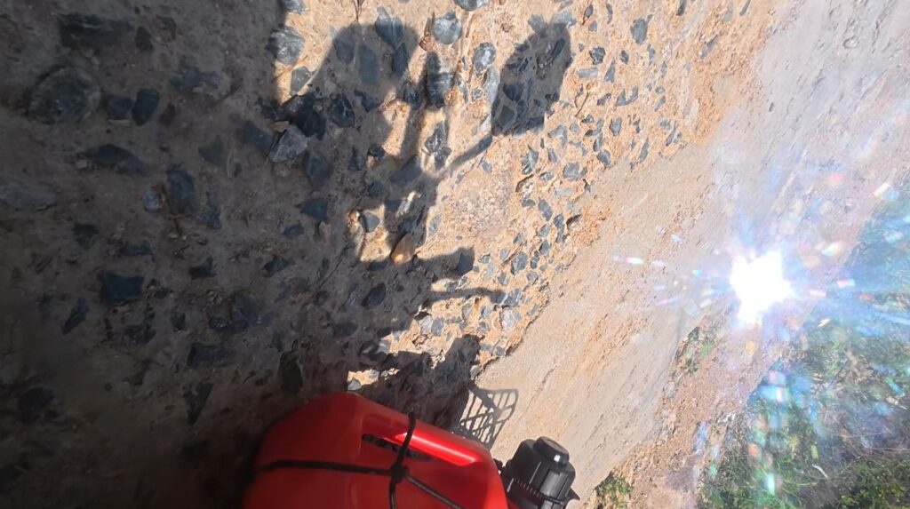 Honda Cub fallen on a steep rocky road while climbing toward Khao Makhem campsite
