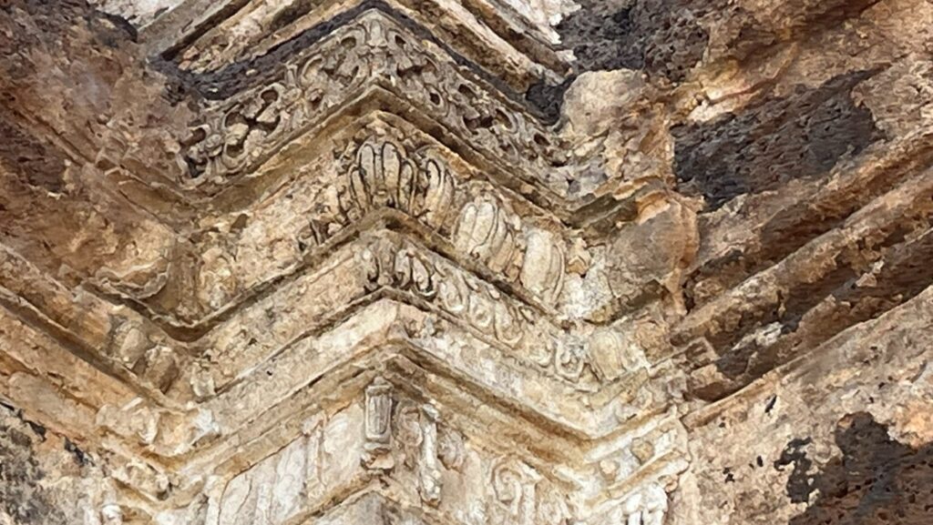 Weathered Khmer carvings on Phra Prang Sam Yot temple wall in Lopburi