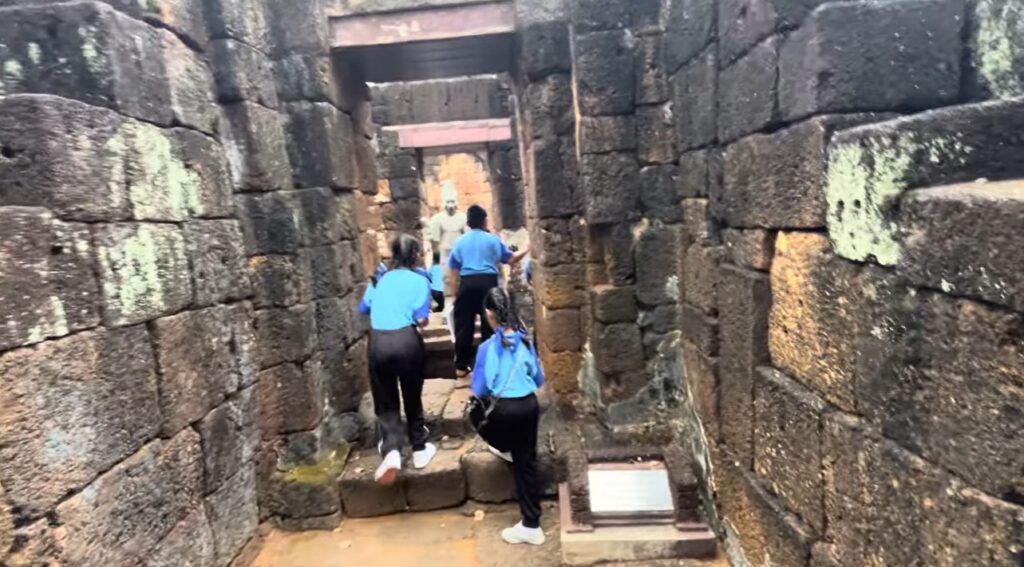Students walking among ancient ruins at Mueang Sing Historical Park