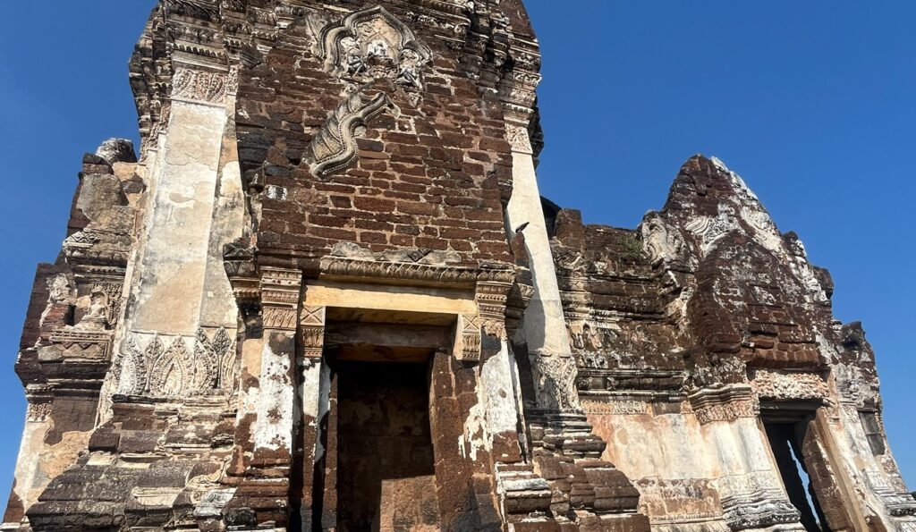 Surviving ancient prangs and brick ruins under the blue sky at Wat Phra Si Rattana Mahathat