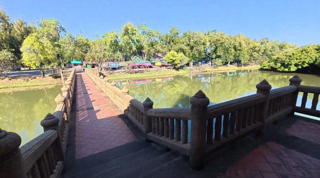 Wooden bridge crossing the pond at Sai Ngam Park in Phimai