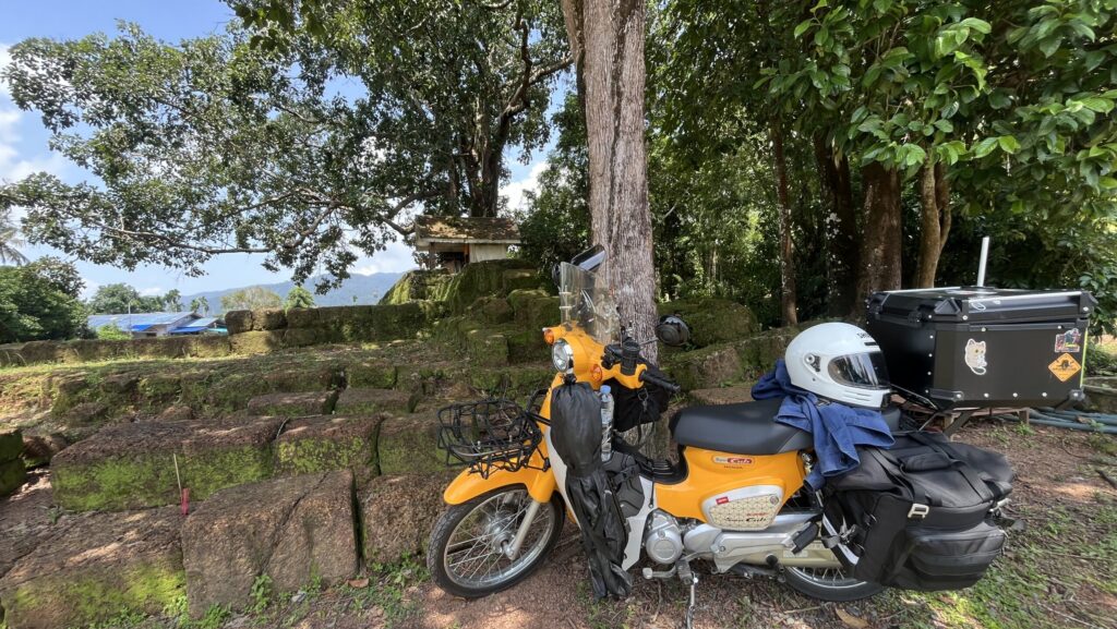 Honda Super Cub beside the ancient Khmer ruins at Muang Paniat Archaeological Site, Chanthaburi, Thailand