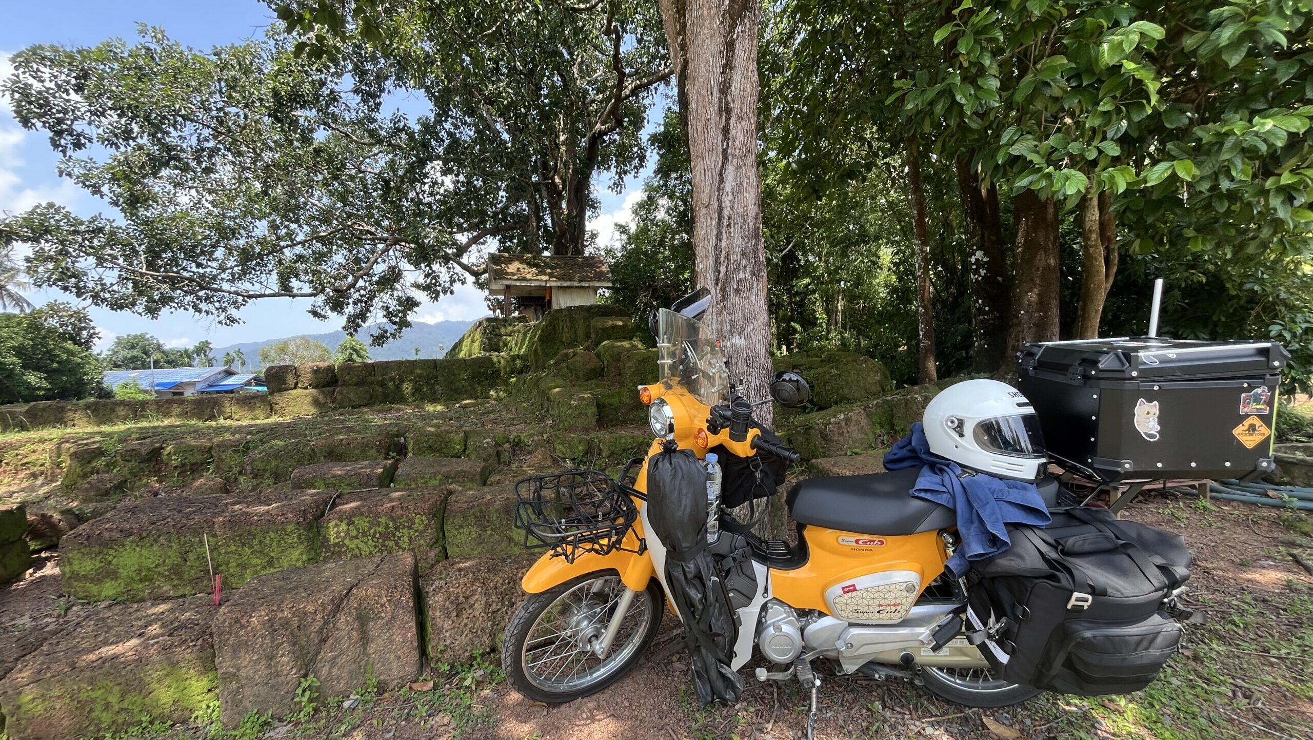 Honda Super Cub beside the ancient Khmer ruins at Muang Paniat Archaeological Site, Chanthaburi, Thailand