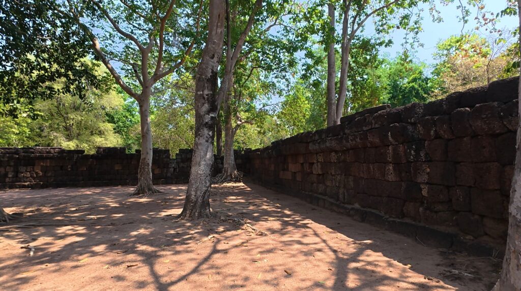 Ancient outer wall of Sadok Kok Thom beneath the trees
