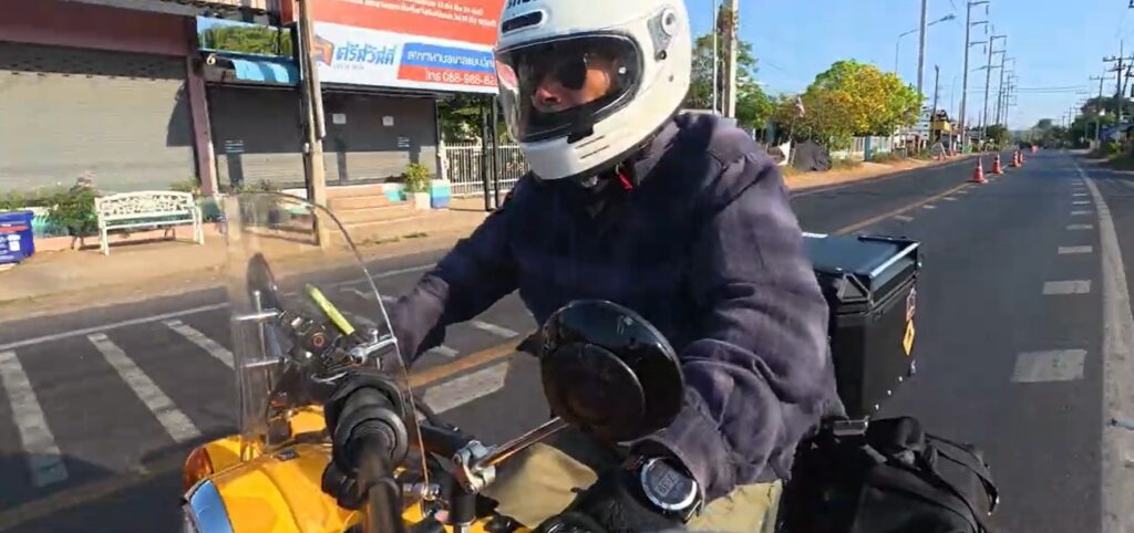 Honda Cub rider on the road to Sadok Kok Thom Historical Park