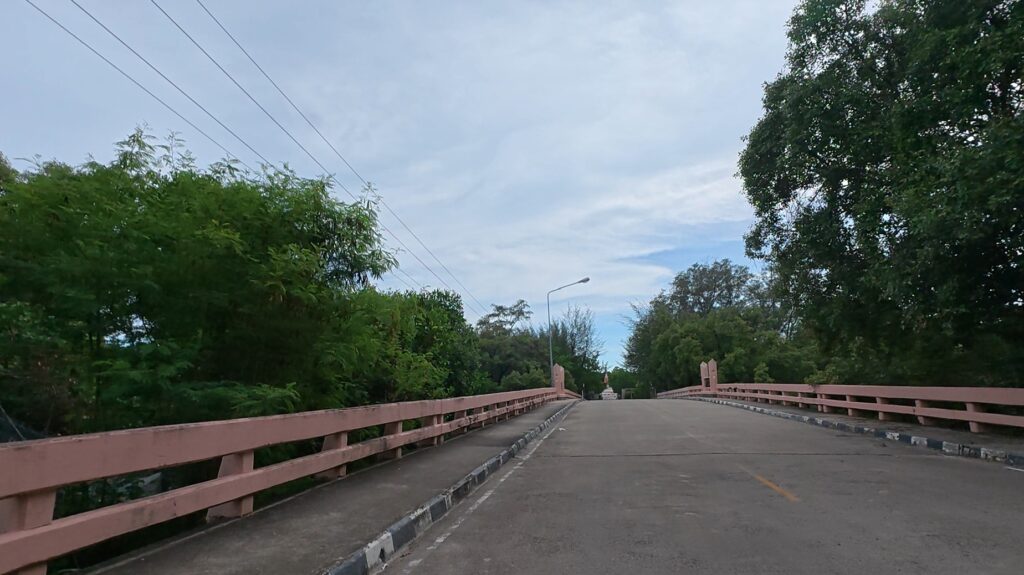 Riding across a bridge near Phra Chedi Klang Nam in Rayong