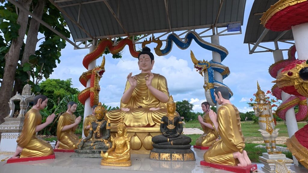 Buddha teaching disciples among sacred guardian figures in a Thai sanctuary