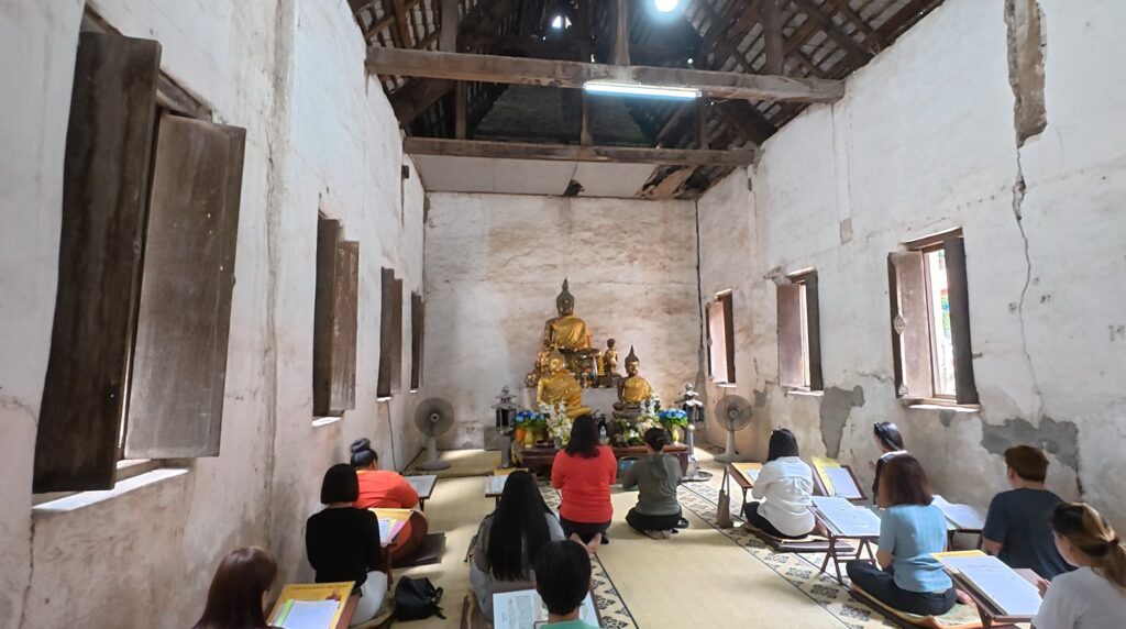 Worshippers praying inside the old ubosot of Wat Khao Bot in Rayong