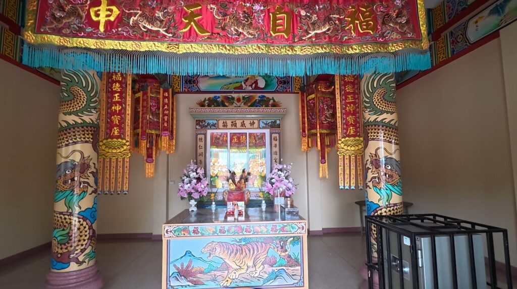 Religious statues and offerings inside the Chinese shrine