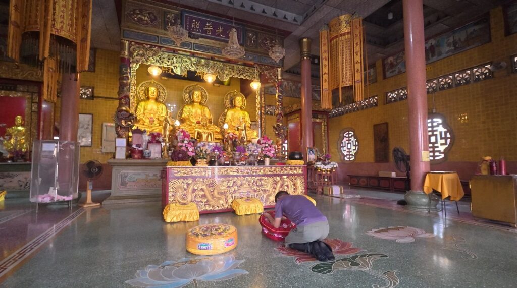 The Main Hall of Wat Mangkorn Buppharam with golden Buddha statues and traditional Chinese Buddhist decorations