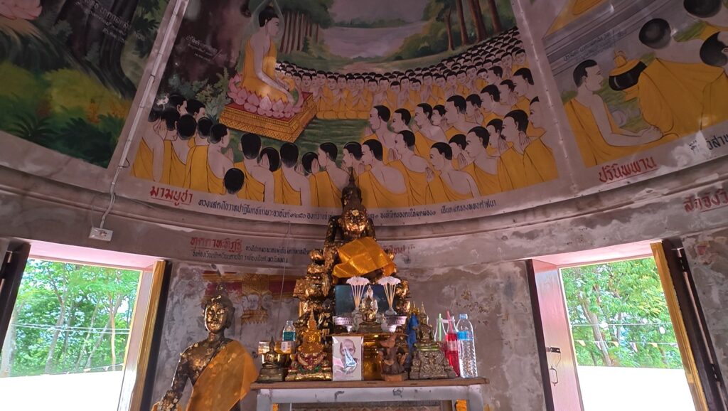 Painted Buddhist ceiling and Buddha image inside the hillside prayer hall