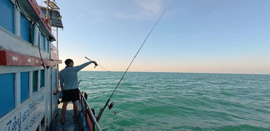 Small fishing boat heading out across the calm sea