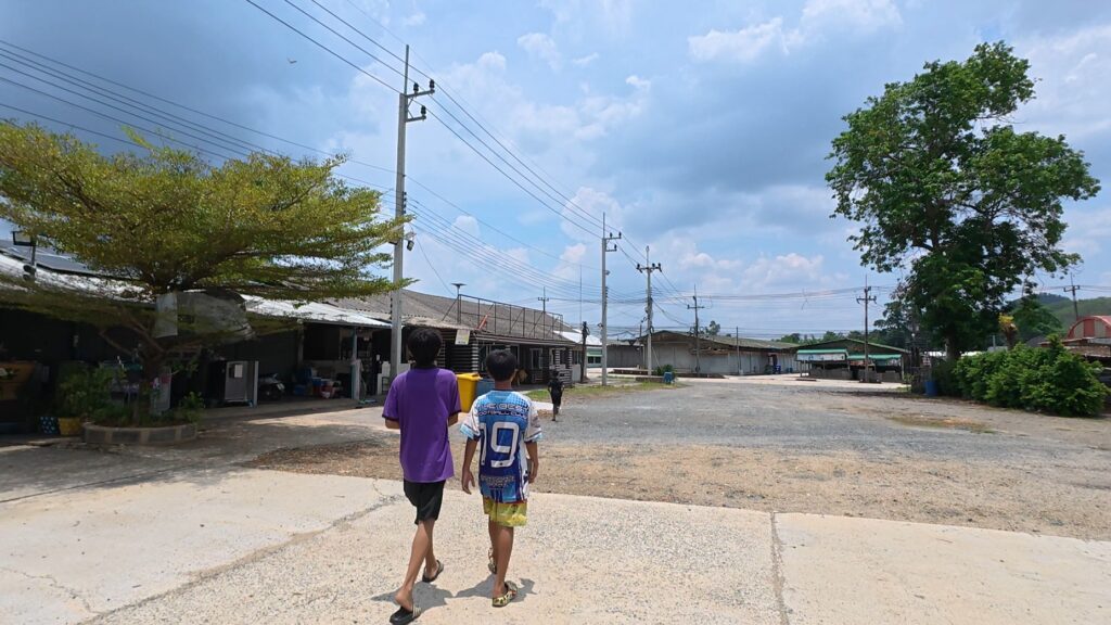 Children walking through the quiet Ban Pakkad border village
