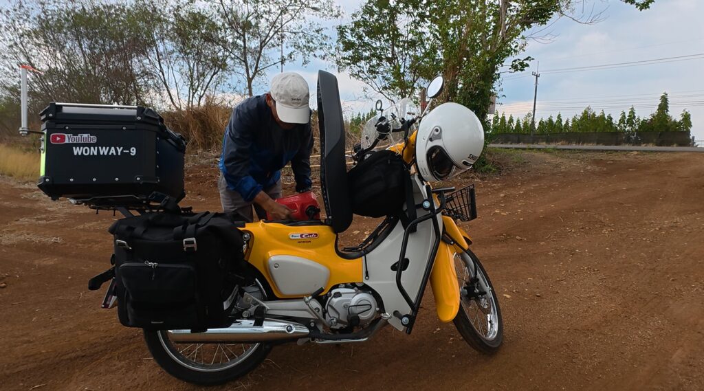 Refueling the Honda Cub after visiting Ban Pakkad Border Checkpoint