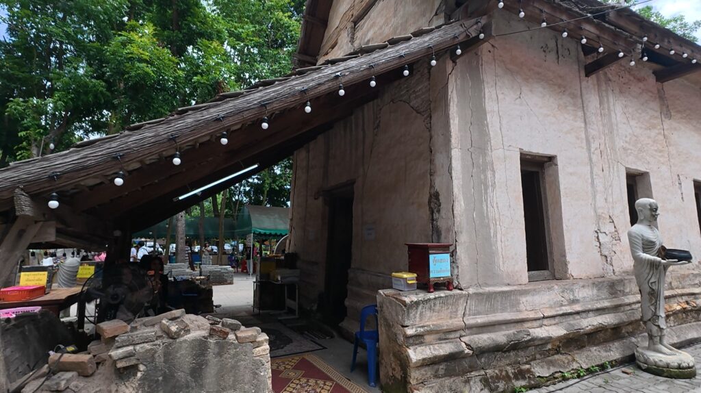 Cracked walls and weathered exterior of the old Wat Khao Bot ubosot