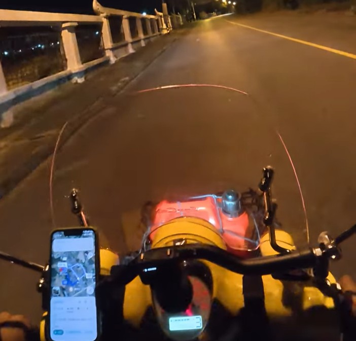 Honda Cub riding through a dark road on the final night home