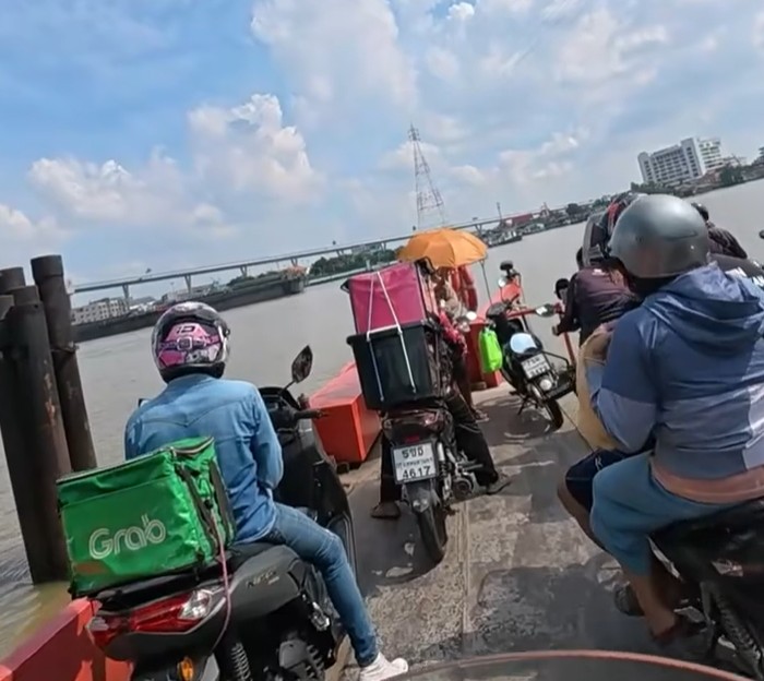 Honda Cub waiting with local motorcycles at a Bangkok ferry crossing