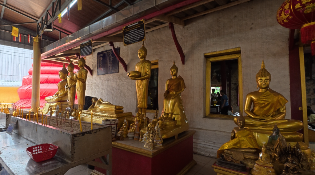 Old Buddha images beside the historic ubosot of Wat Tao Pun