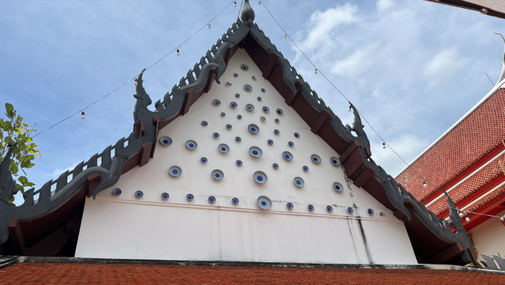 Blue-and-white ceramic plates decorating the gable of the old ubosot at Wat Taphong Nai
