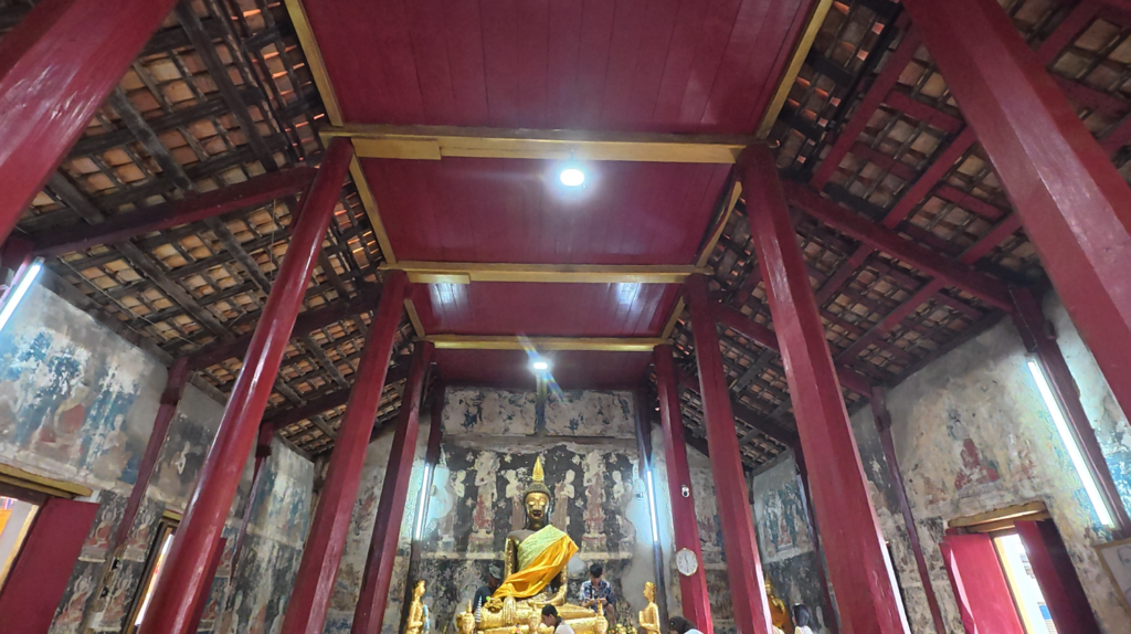 Timber roof and red columns inside the historic ubosot of Wat Tao Pun